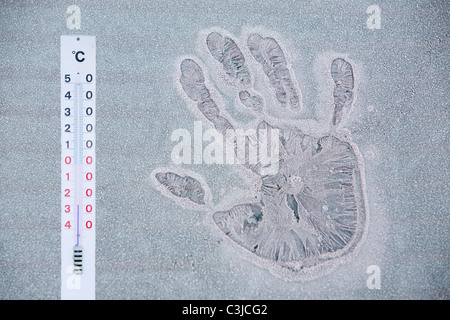 Una mano froaen stampa su un iced oltre la finestra Auto in Ambleside Cumbria Regno Unito Foto Stock