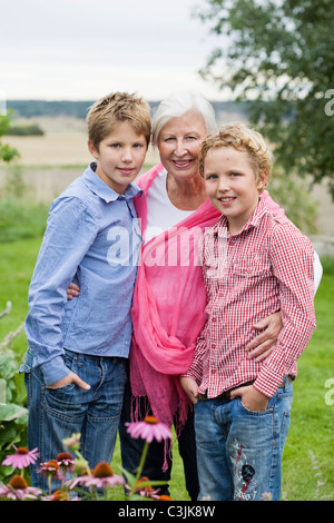 Nonna con nipoti in giardino Foto Stock