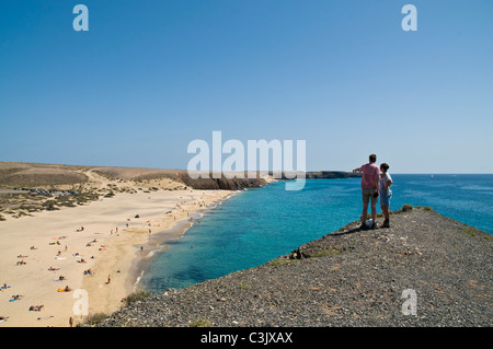 dh Playa Mujeres spiaggia Canarie PAPAGAYO LANZAROTE Coppia turistica con vista sulla baia persone al mare isole canarie turisti Foto Stock