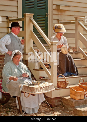 Indossando costumi storici, reenactors dimostrare il cestello storico-competenze di tessitura di Colonial Williamsburg, VA. Foto Stock
