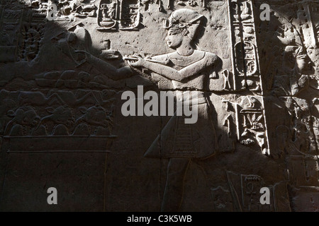 Primo piano di Re con bruciatore incenso su parete parzialmente ombreggiata al Tempio di Luxor, Luxor, Egitto Foto Stock