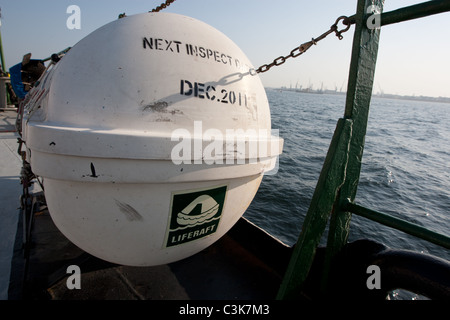 Emergency self distribuzione e auto il gonfiaggio di zattera di salvataggio su un ponte di una nave in mare. Foto Stock