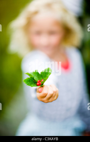 Ragazza con ribes rosso con foglie, close-up Foto Stock
