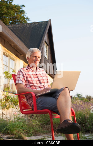 Uomo con notebook davanti la casa Foto Stock