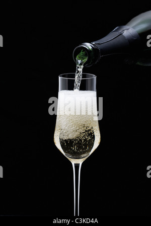 Champagne essendo versando in vetro dalla bottiglia, close-up Foto Stock