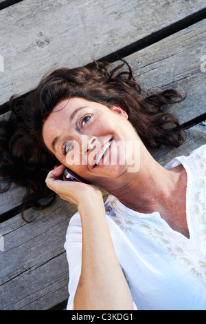 Una donna su un molo da un lago, Svezia. Foto Stock