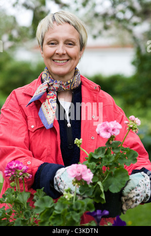 Una donna piantare fiori, Svezia. Foto Stock