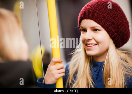 Ragazza adolescente (14-15) in treno sotterraneo Foto Stock