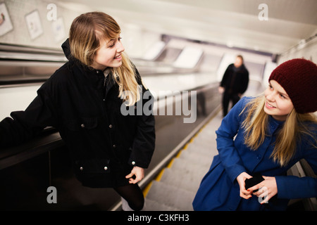 Due ragazze adolescenti (14-15) in Escalator Foto Stock