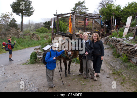 Un asino e turisti sul percorso del pellegrinaggio in Manjarin, Camino de Santiago, Spagna settentrionale Foto Stock