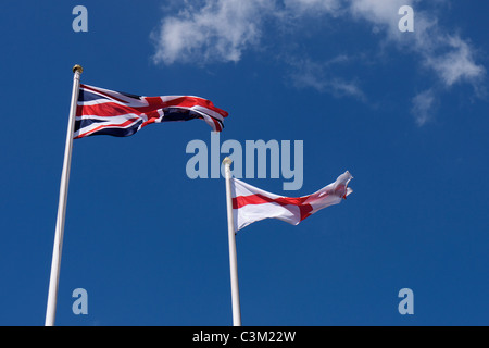 Due bandiere nel vento: una bandiera europea e una bandiera inglese Foto Stock