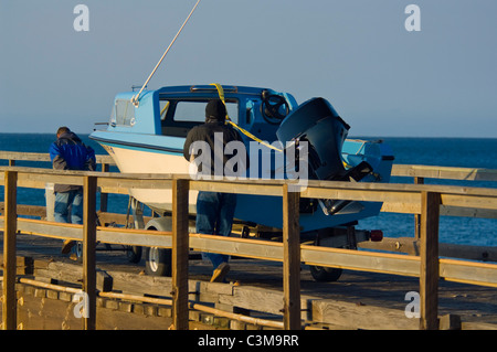 L'uomo tirando una piccola imbarcazione a motore sul molo Gaviota Beach State Park, vicino a Santa Barbara in California Foto Stock