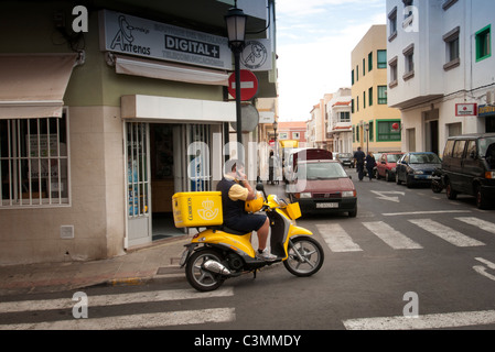 Correos postino sulla moto di prendere una chiamata sul cellulare Fuerteventura Foto Stock