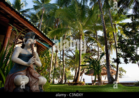 Indonesia, isola di Bali, vicino al villaggio di Tejakula, Gaia Oasis Resort. Statua di fronte al bungalow. Foto Stock