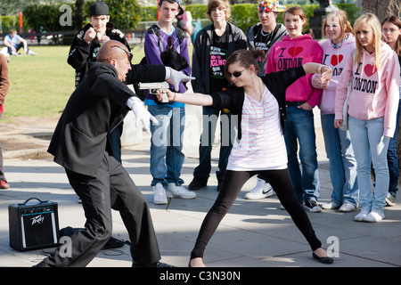 Street esecutore suona con un volontario sulla South Bank di Londra. Foto Stock