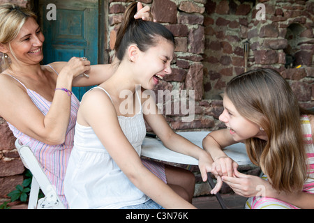 La madre e le figlie ridere insieme Foto Stock