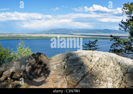 Questo file di log e di Boulder si affacciano del Wyoming Lake Jenny nel Parco Nazionale di Grand Teton, Wyoming. Foto Stock