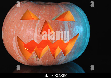 La zucca con illuminazione candela interna su sfondo nero Foto Stock