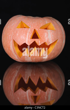 La zucca con illuminazione candela interna su sfondo nero Foto Stock