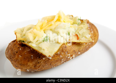 Una piastra con una cotta idaho patate russet aprirsi e crema con burro e prezzemolo fresco, guarnita con formaggi misti Foto Stock