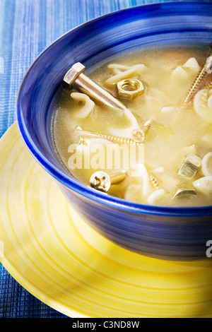 Ciotola di zuppa con i chiodi in esso. Foto Stock