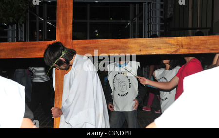 Gesù, bianche vesti, flagellato da un helper che porta la croce in una processione del Venerdì santo, vicino alla Cattedrale di Santiago del Cile Foto Stock