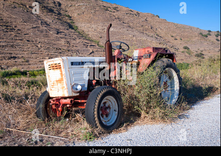 La Bielorussia T-25 fattoria abbandonata del trattore sul lato di una strada in Greco Cyclade isola di Tinos. Foto Stock