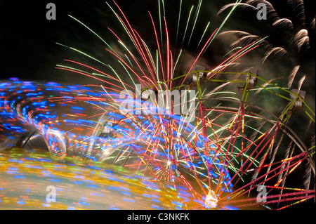 Evergreen State Fair ruota panoramica Ferris di notte con giostre e movimento con fuochi d'artificio Snohomish nella Contea di Monroe Stato di Washington STATI UNITI D'AMERICA Foto Stock