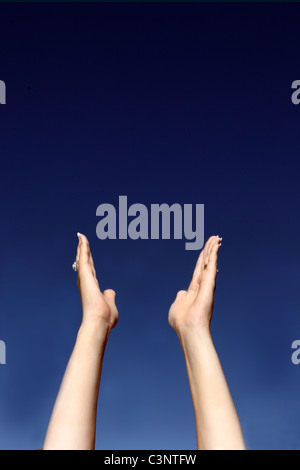 Womans mani fino a raggiungere il cielo azzurro è in attesa di prendere qualcosa. Foto Stock