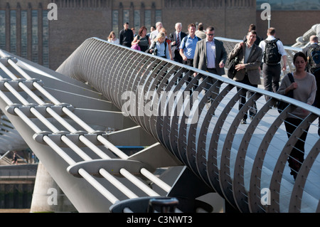 Pendolari che attraversa il Millenium Bridge di Londra, Inghilterra, Foto Stock