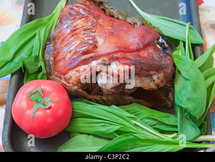 Cotta con spezie un gammon di un piede con pomodoro e foglie di insalata verde Foto Stock