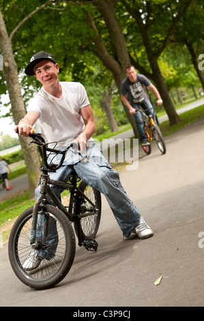 Due ragazzi adolescenti con atteggiamento su BMX stunt bike, REGNO UNITO Foto Stock