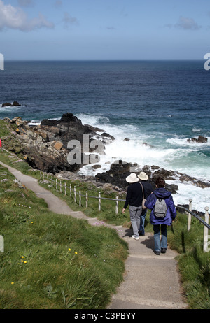 Walkers sul percorso tra Porthgwidden e Porthmeor Beach, l'isola, St Ives, Cornwall Foto Stock