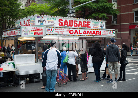 Un stand con vendita di salsicce, calamari e altri Etnico italiano cibo alla Nona Avenue Food Festival a New York Foto Stock