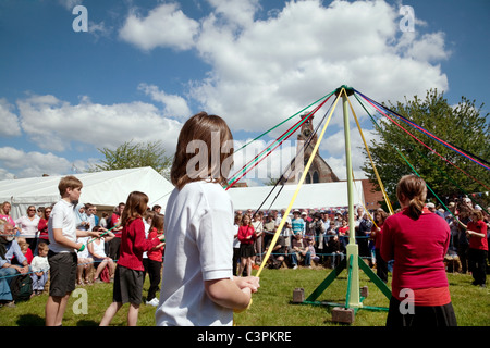I bambini di una scuola elementare locale dancing round il maypole il giorno di maggio a raggiungere la fiera, raggiungere, Cambridgeshire, Regno Unito Foto Stock
