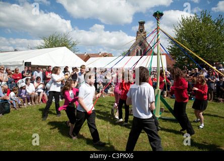 I bambini di una scuola elementare locale dancing round il maypole il giorno di maggio a raggiungere la fiera, raggiungere, Cambridgeshire, Regno Unito Foto Stock