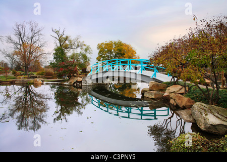 Una scena pastorale di un piede giapponese ponte su un tranquillo laghetto in un giorno di pioggia in autunno, Southwestern Ohio, Stati Uniti d'America Foto Stock