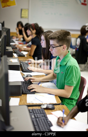 Gruppo di scuola media gli studenti lavorano in modo indipendente tramite computer Foto Stock