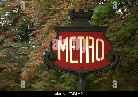 Un iconico cartello parigino in stile Liberty sulla Métro, sullo sfondo di un fogliame, in Avenue des Champs Elysées. Parigi, Francia. Foto Stock