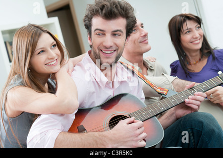 Happy amici a suonare la chitarra insieme Foto Stock