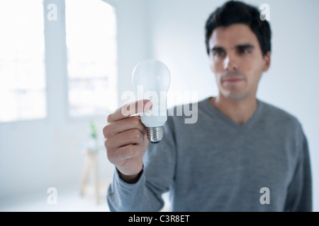 Uomo con una lampadina elettrica Foto Stock