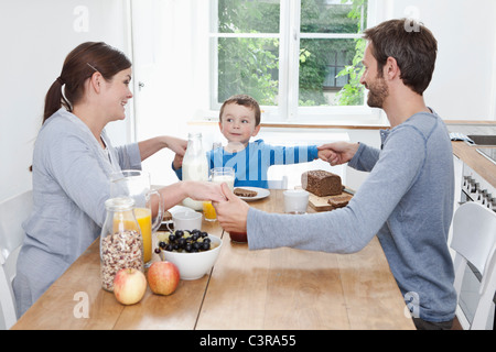 In Germania, in Baviera, Monaco di Baviera, Famiglia avente colazione insieme felicemente Foto Stock