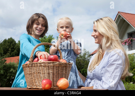 Germania - Monaco, madre con i bambini a mangiare le mele dal carrello Foto Stock