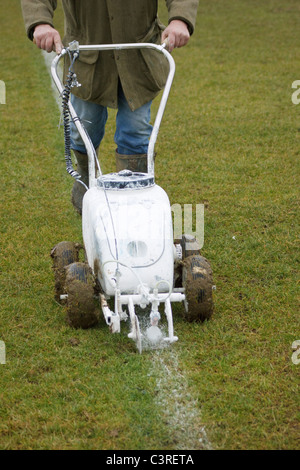 Pittura Groundsman linee bianche sul campo di calcio con una spinta lungo la macchina Foto Stock