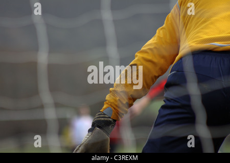 Il portiere giocando a calcio nella parte anteriore del calcio net Foto Stock