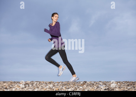 Donna stretching sulla spiaggia Foto Stock