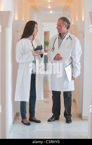 Medici ispanica insieme permanente nel corridoio di ospedale Foto Stock