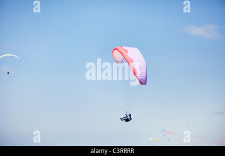 Persona parapendio contro il cielo blu Foto Stock