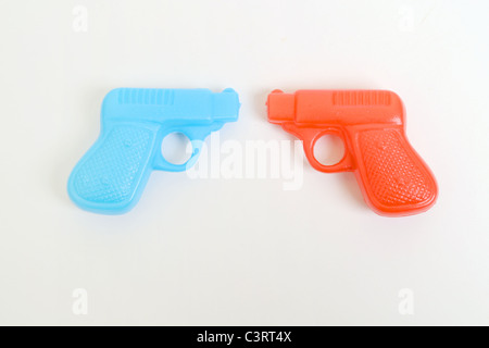 Stallo del giocattolo di plastica pistole pistole Rosso Blu colori metafora guerra paesi i sessi sesso unite dalla guerra civile Foto Stock