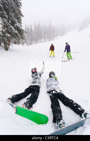 Gli appassionati di snowboard di scattare una foto di sciatori Foto Stock